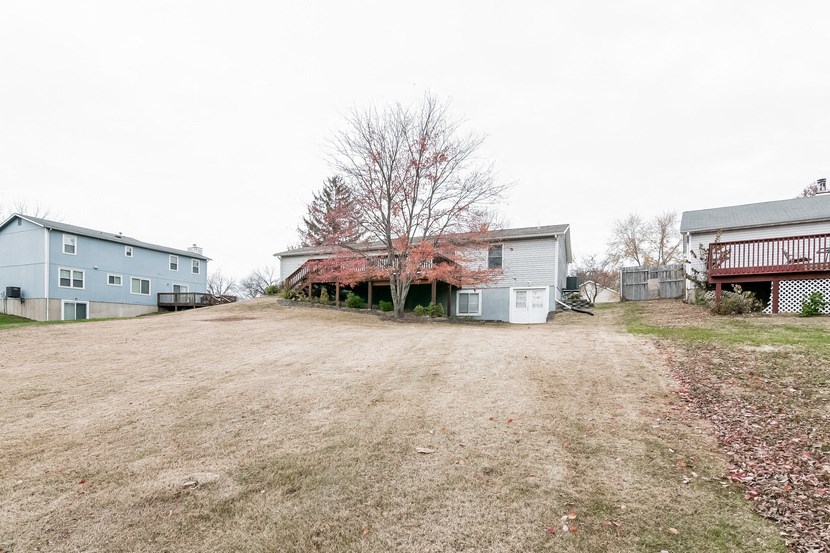 a house with a yard and a blue house and a red roof