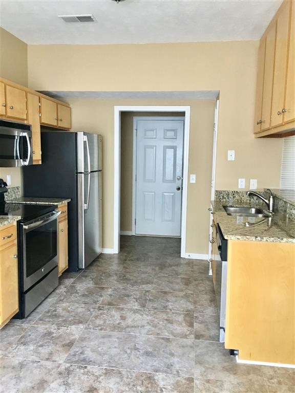a kitchen with a stove refrigerator and a sink