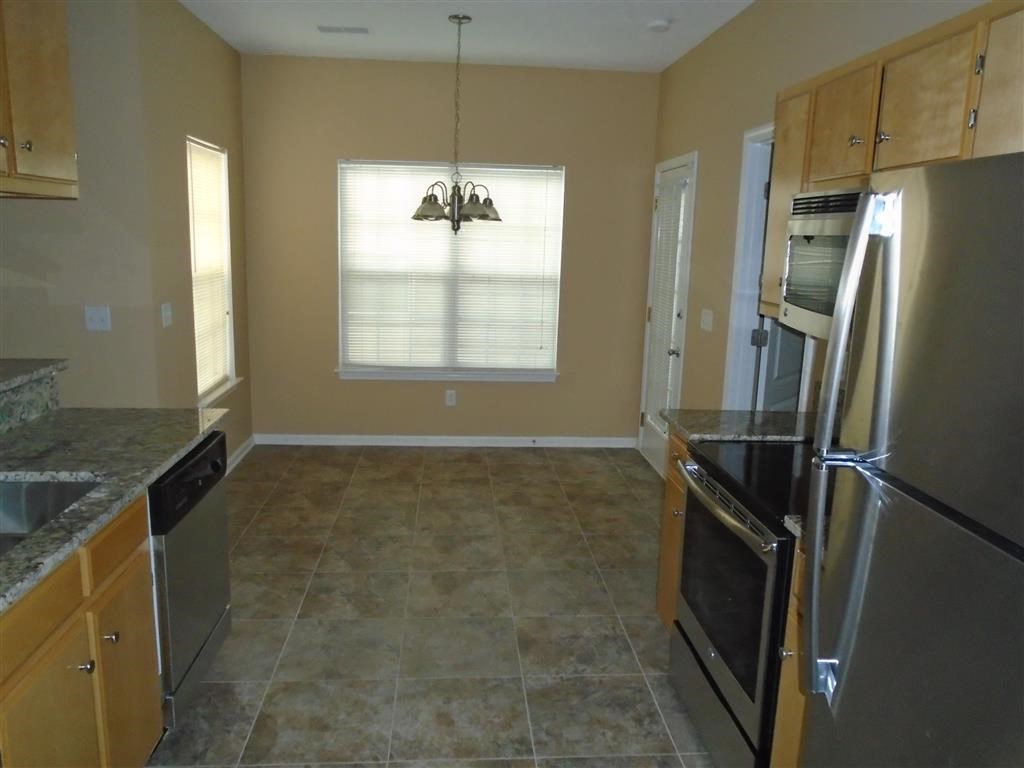 a kitchen with stainless steel appliances and tiled floors