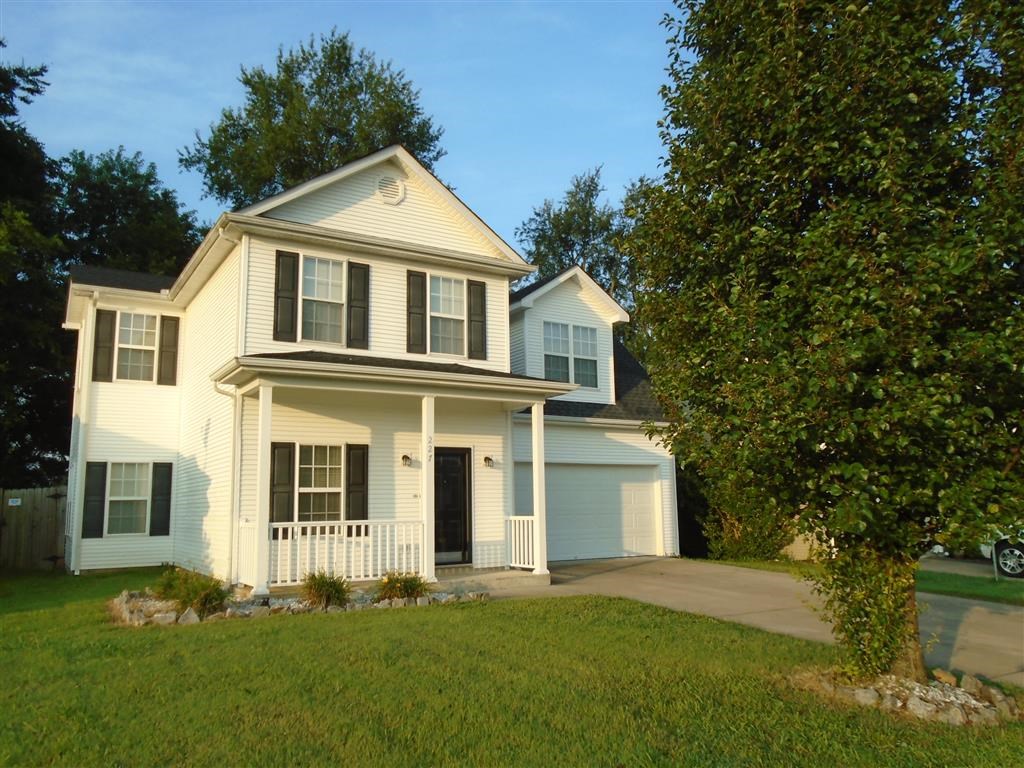 a white house with a yard and a tree