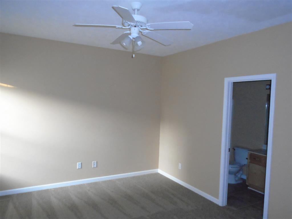 a empty living room with a ceiling fan