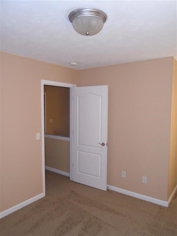 an empty room with a white door and a closet