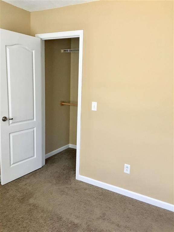 an empty room with a closet and a white door