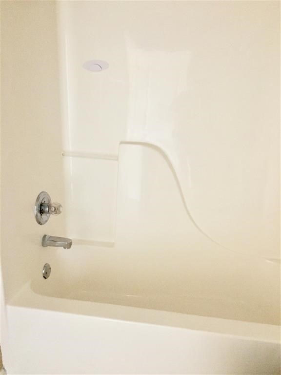 a white bath tub with a silver faucet in a bathroom