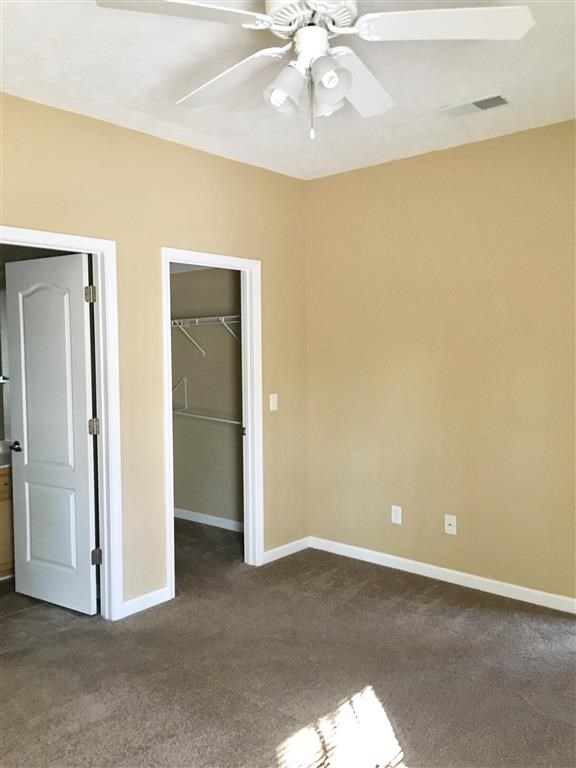 an empty room with a ceiling fan and a closet