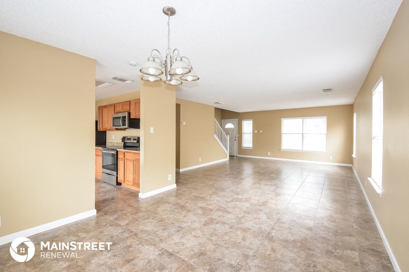 the living room and dining room with the kitchen in the background