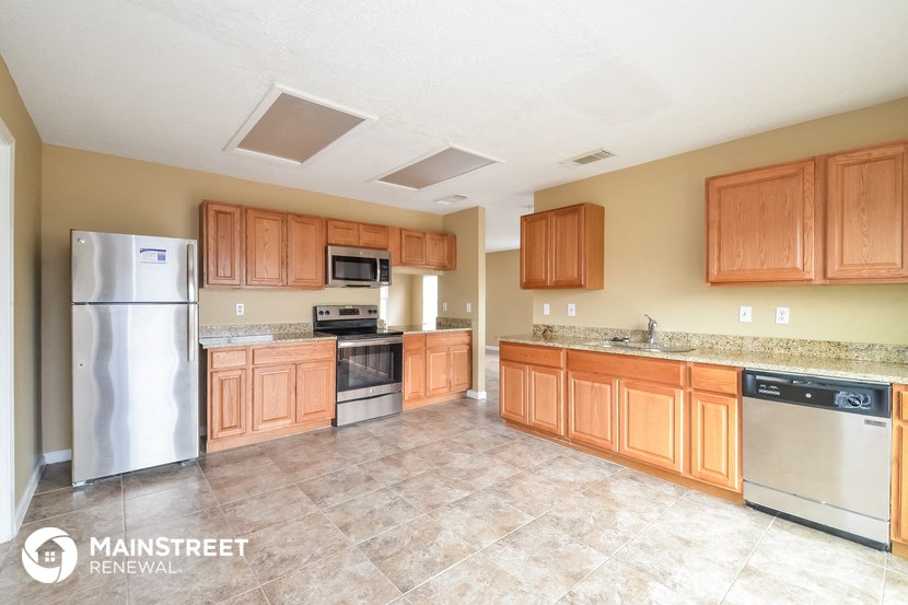 a large kitchen with wooden cabinets and stainless steel appliances