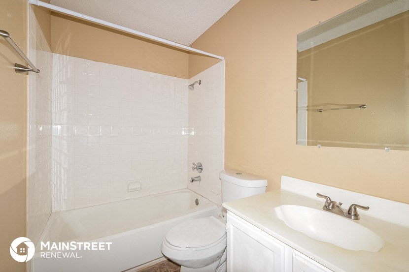 a bathroom with a toilet sink and tub and a mirror