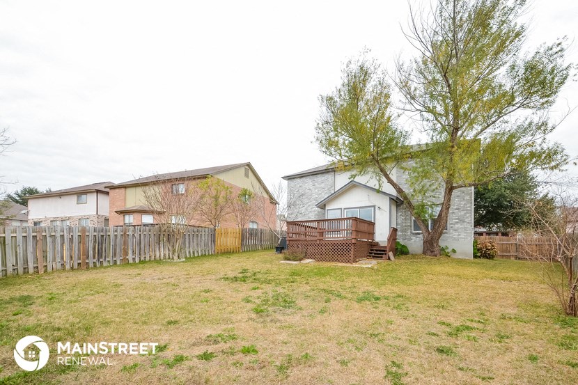 the backyard of a house with a yard and a fence