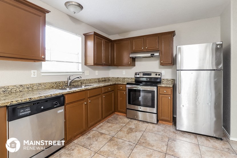 a kitchen with wooden cabinets and stainless steel appliances