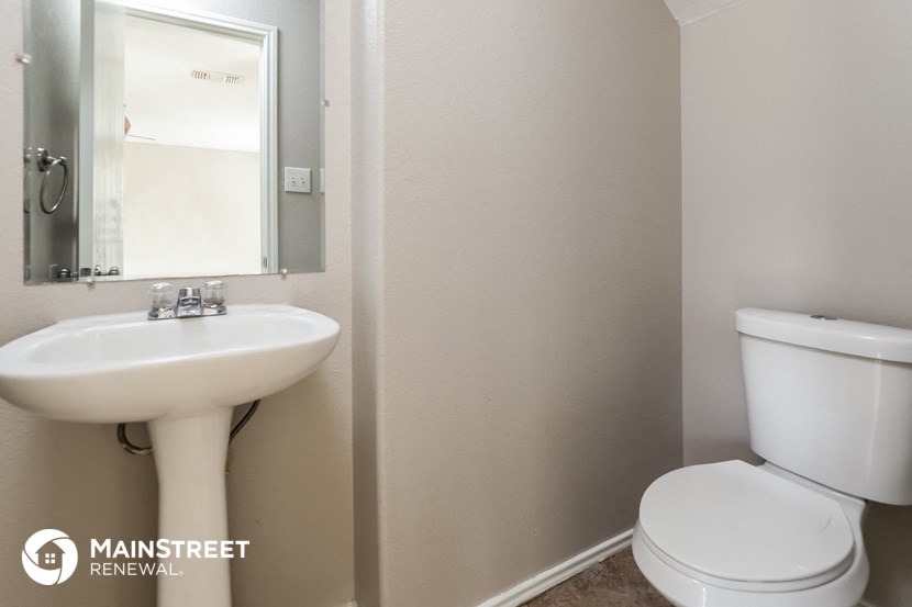 a bathroom with a sink toilet and a mirror