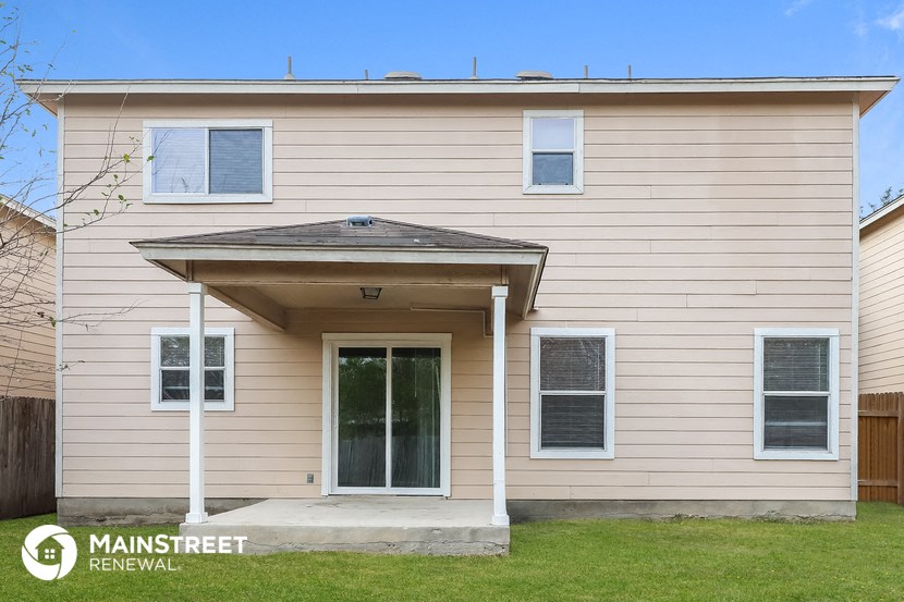 the front of a tan house with a front porch