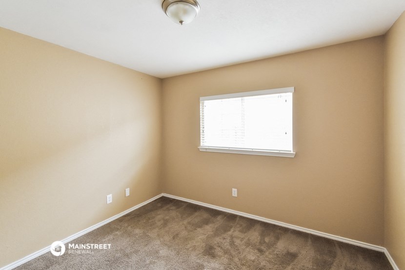the upstairs bedroom with carpet and a window