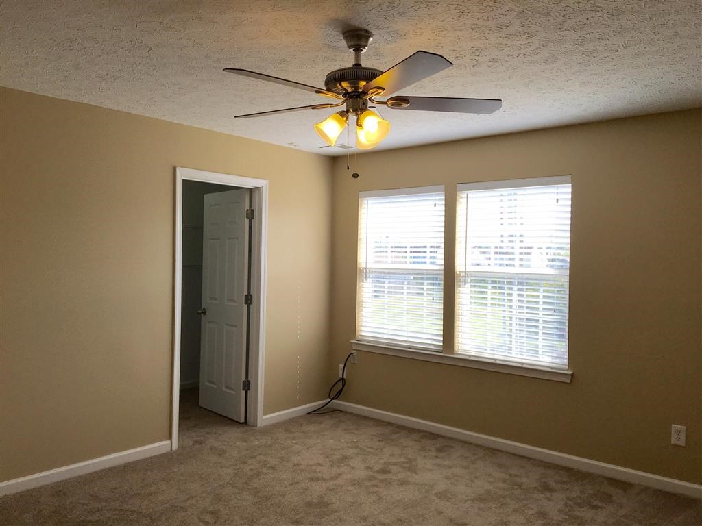 a bedroom with a ceiling fan and a window