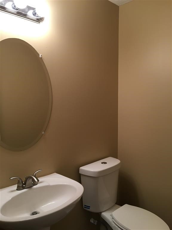 a bathroom with a toilet and a sink and a mirror