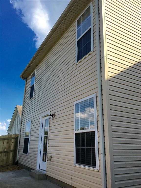 a white house with white siding and a blue sky