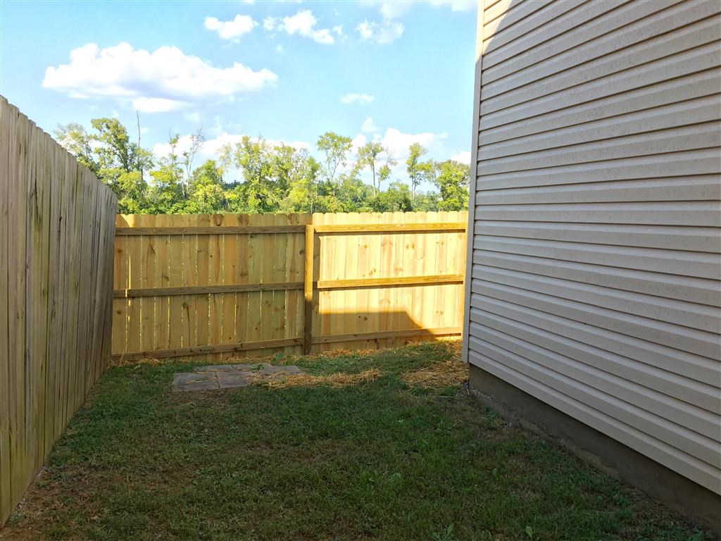a backyard with a wooden fence and a privacy fence