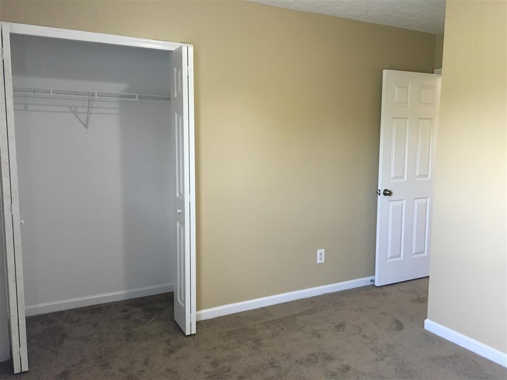 an empty room with a closet and a door