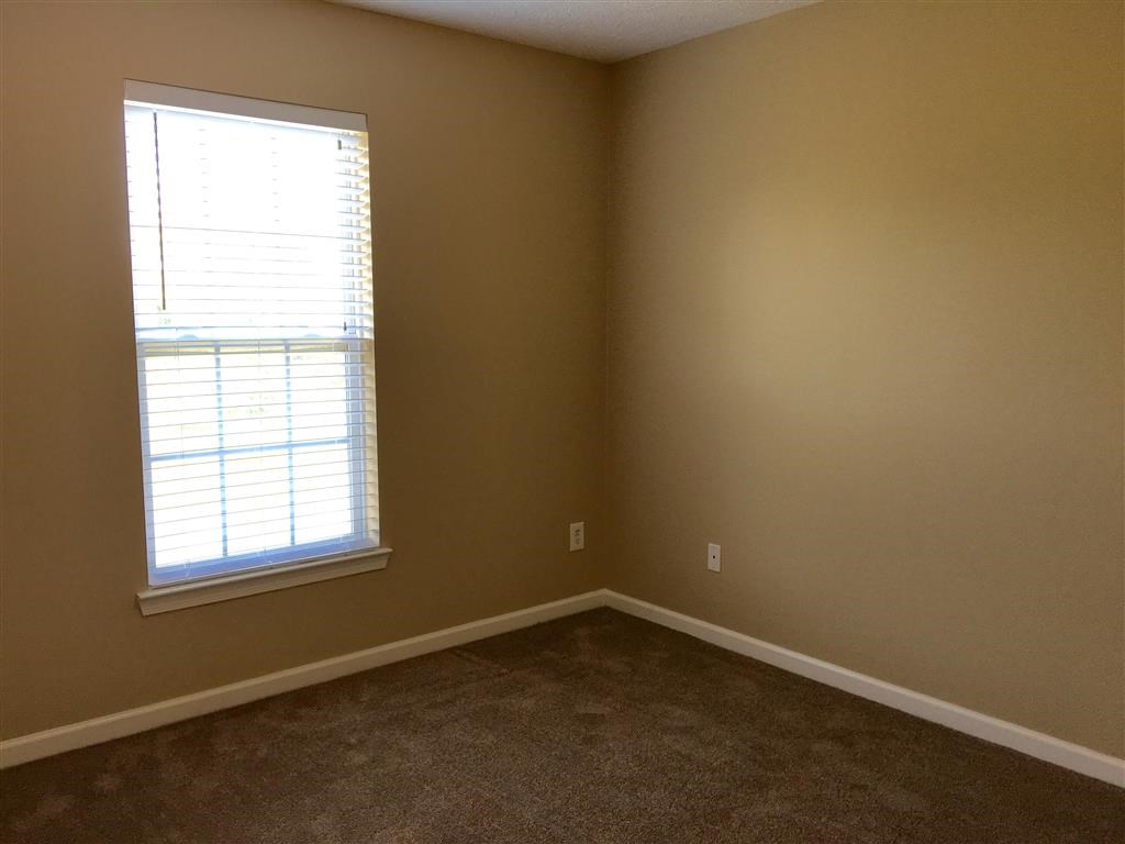 a room with a window and a carpet