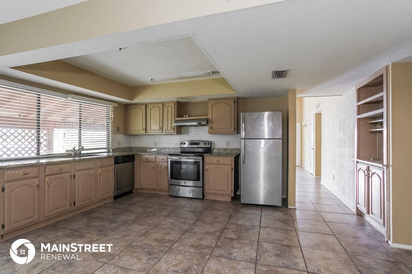 a large kitchen with stainless steel appliances and wooden cabinets