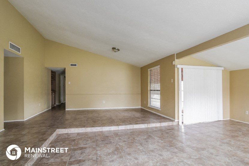 the spacious living room with tile flooring and yellow walls