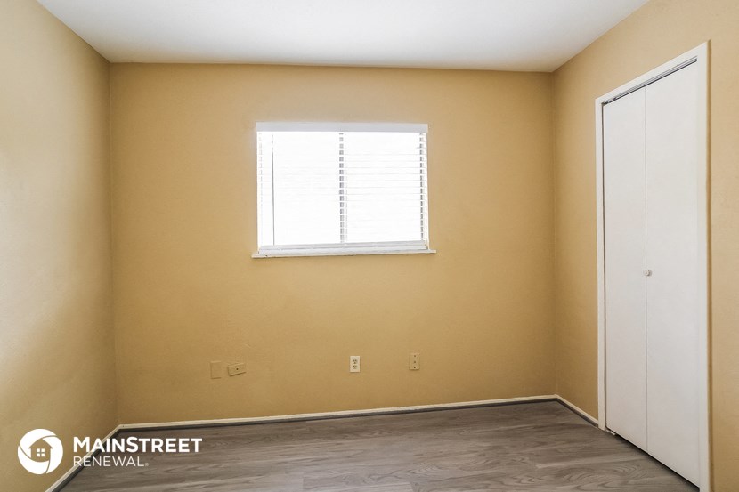 the interior of an empty room with a window and a door