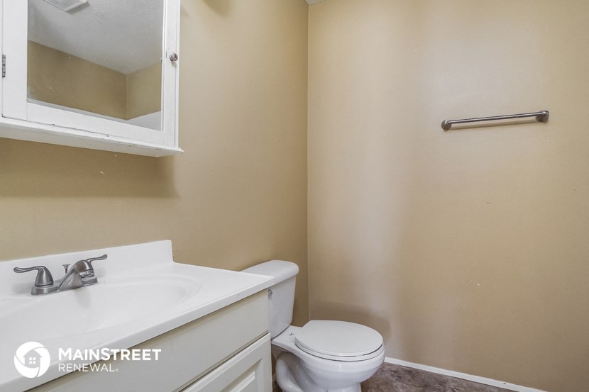 a bathroom with a toilet and a sink and a mirror