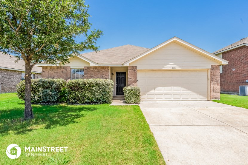 a house with a driveway and a tree in front of it