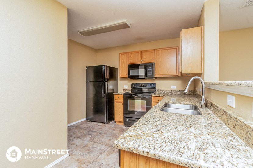 a kitchen with a granite counter top and a black refrigerator