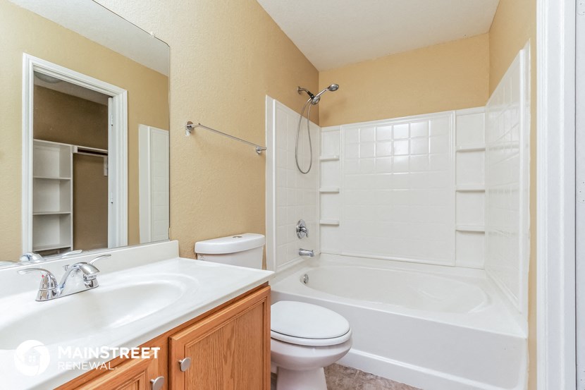 a bathroom with a tub sink and toilet and a mirror