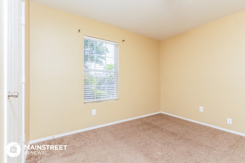 a spacious room with carpet and a window