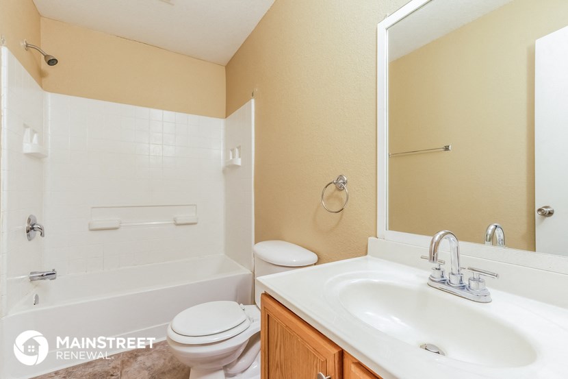 a bathroom with a sink toilet and tub and a mirror