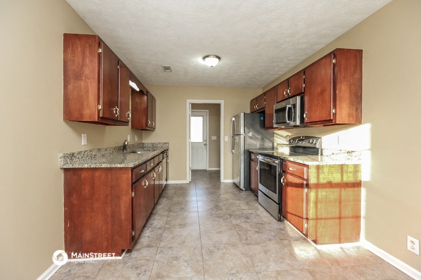 a kitchen with wooden cabinets and stainless steel appliances