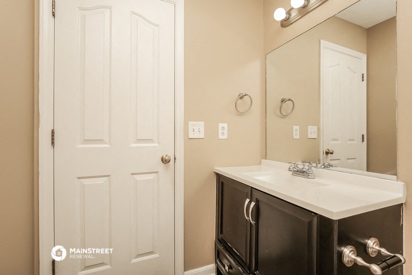 a bathroom with a sink and a mirror and a door