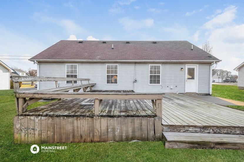 a small white house with a deck and a dock