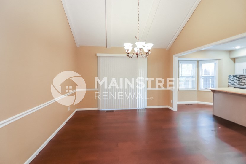 a large living room with wood floors and a large window