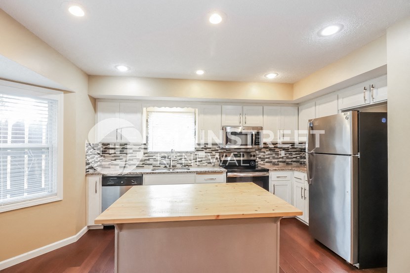 a kitchen with a large island and stainless steel appliances