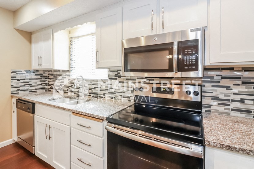 a kitchen with stainless steel appliances and white cabinets