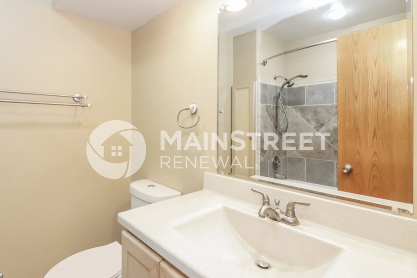 a bathroom with a sink and a shower and a toilet