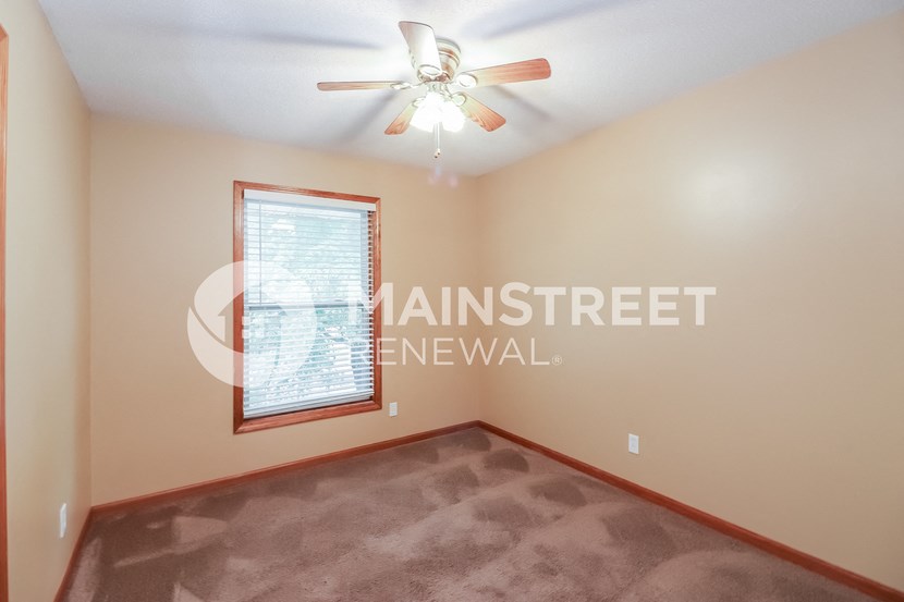a living room with a ceiling fan and a window