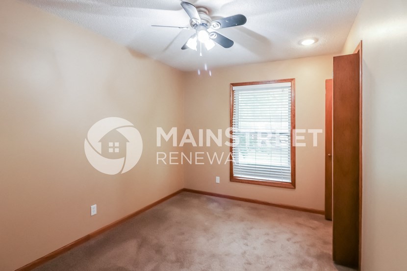 a living room with a ceiling fan and a window