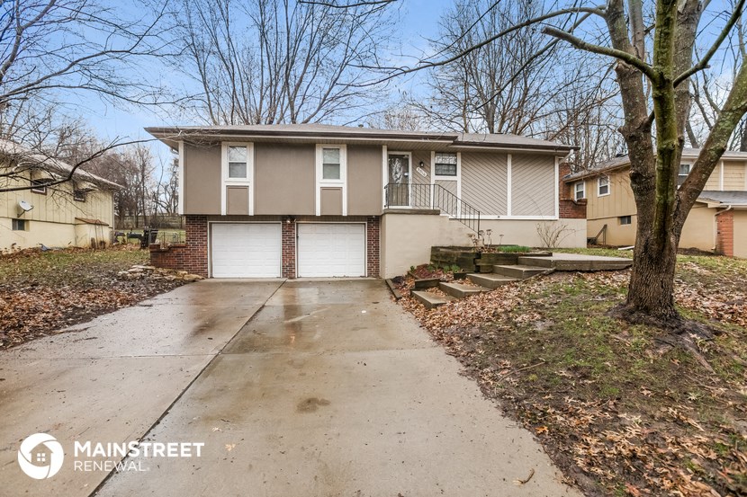 the front of a house with a driveway and a garage door