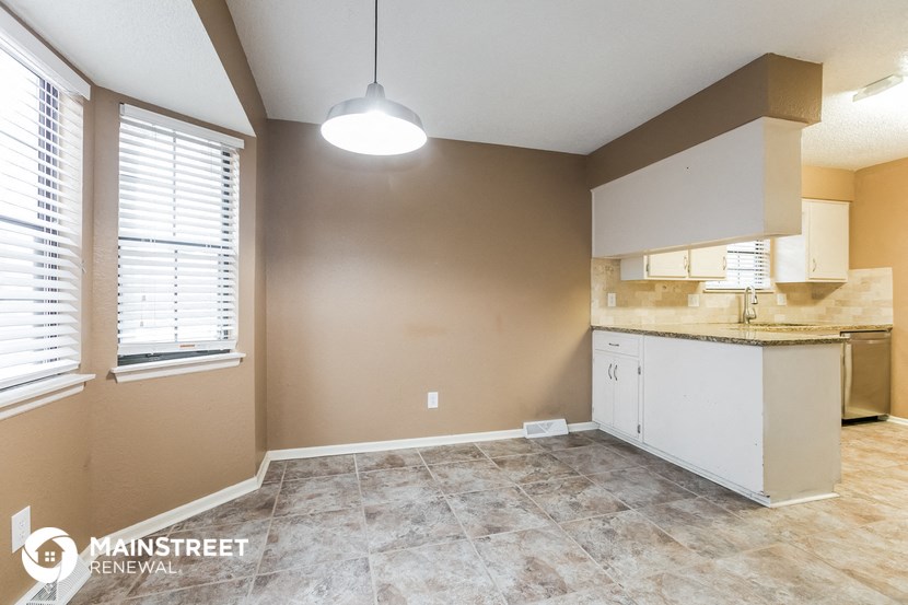 the kitchen and dining area of a renovated home with a large window