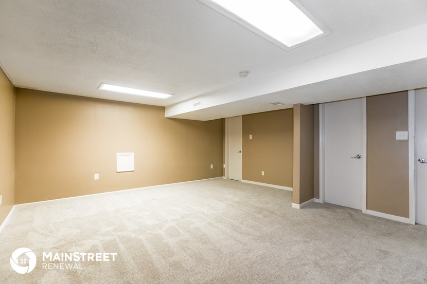 the living room of an apartment with a carpeted floor and doorways