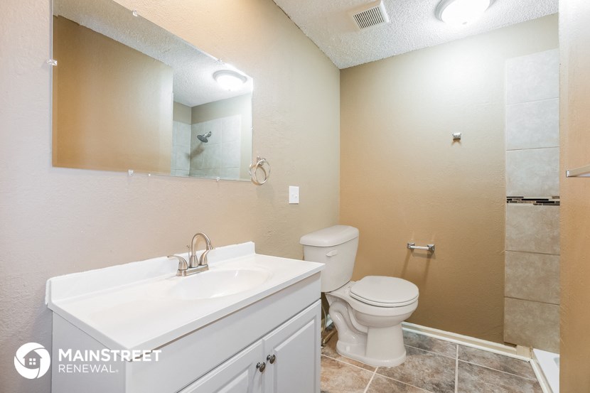 a bathroom with a toilet and a sink and a mirror