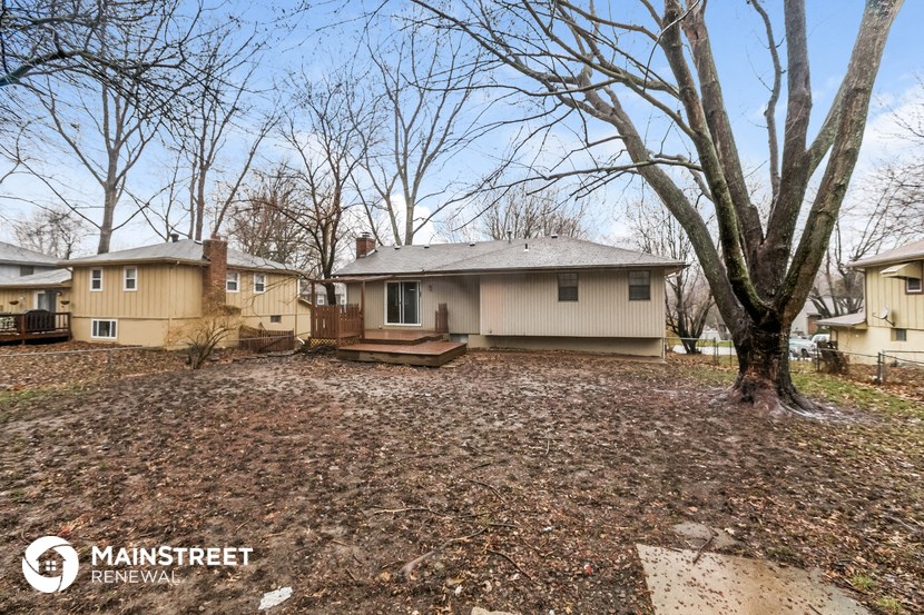 the front yard of a house with a large tree