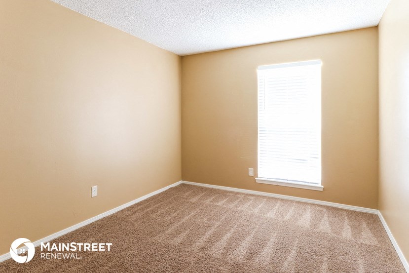a large room with carpet and a window