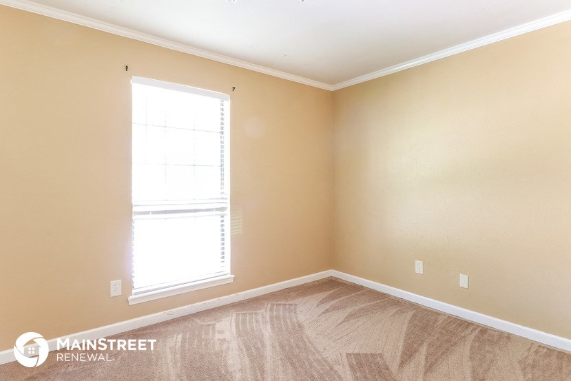 a bedroom with a window and a wooden floor