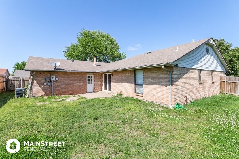 a brick house with a yard and a blue roof
