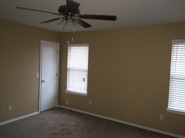 a living room with a ceiling fan and a door